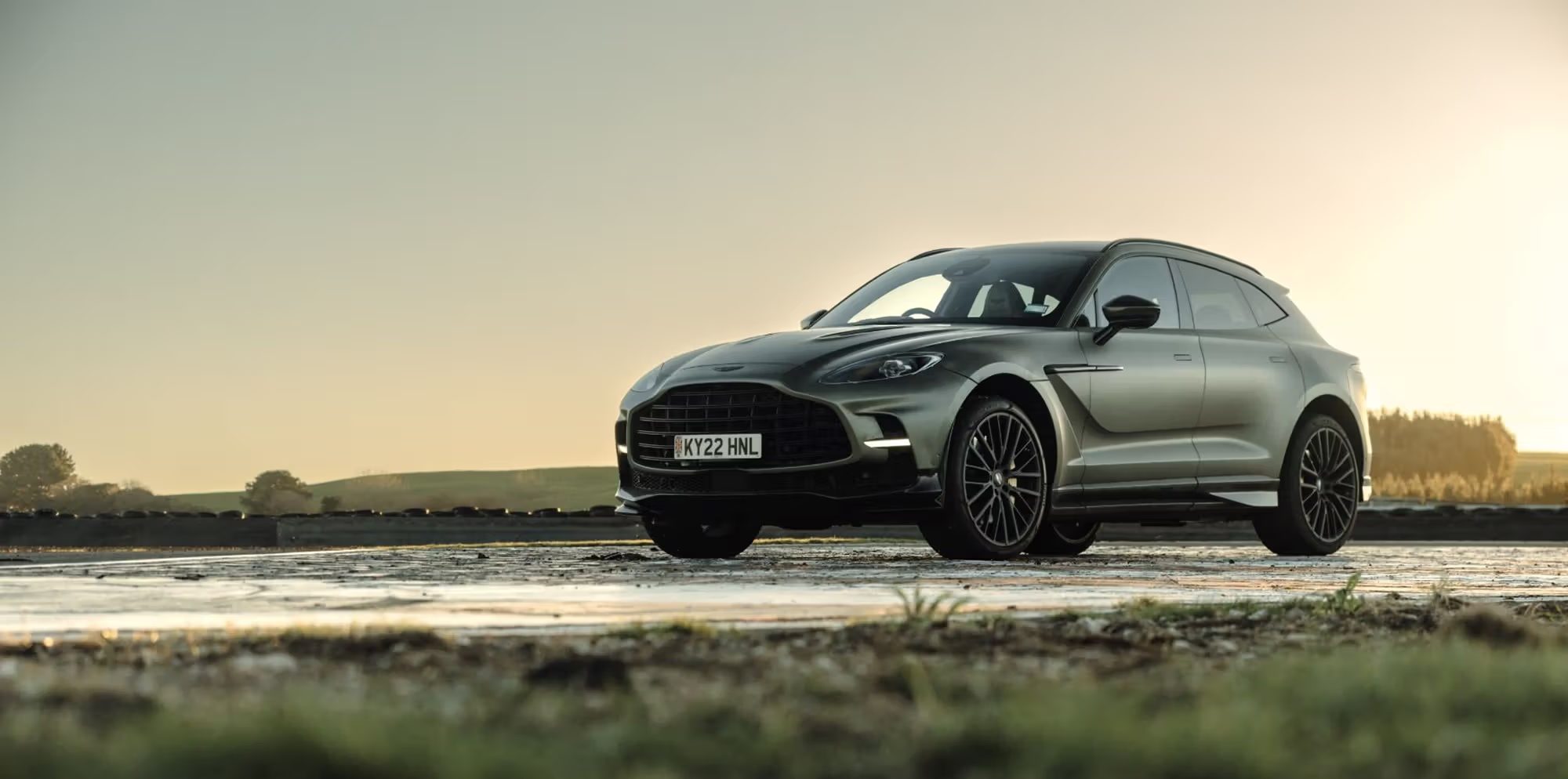 Aston Martin DBX cinzento ao pôr do sol